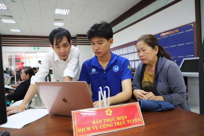 Cán bộ Trung tâm phục vụ hành chính công phường Phú Nhuận, TP HCM, hỗ trợ người dân nhập thông tin lên Cổng dịch vụ công quốc gia, ngày 23/7. Ảnh: Lê Tuyết