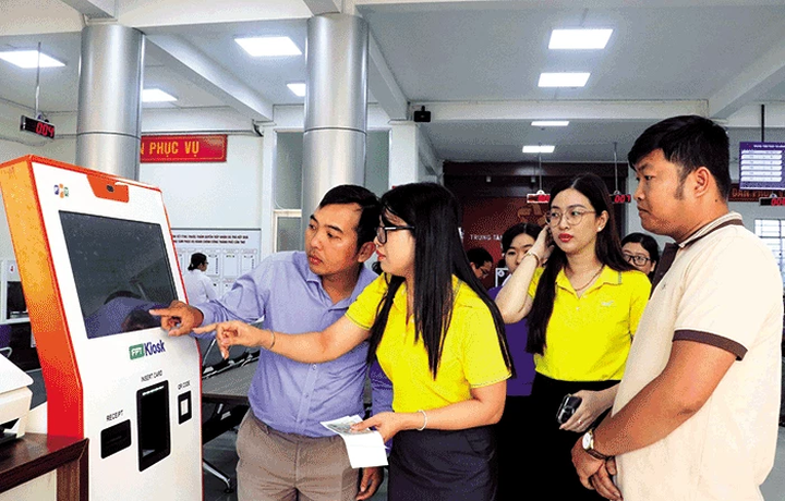 Nhân viên hướng dẫn người dân đăng ký thực hiện TTHC bằng thiết bị Smart Kiosk tại Trung tâm Phục vụ hành chính công TP Cần Thơ.